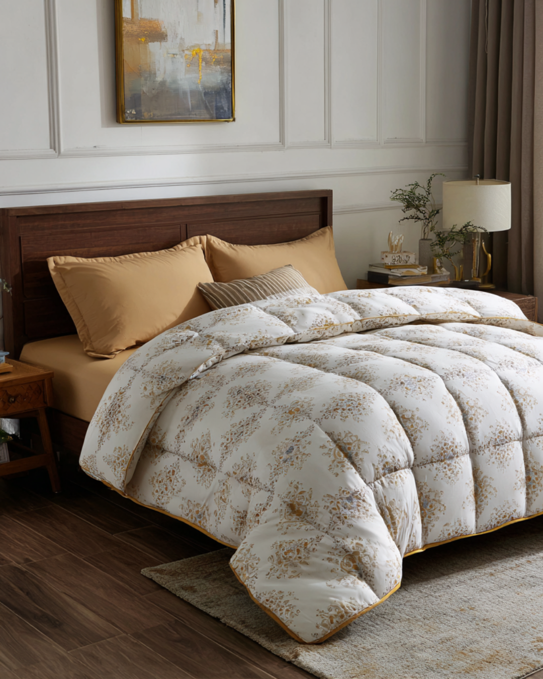 A neatly made bed with tan sheets, three pillows, a wooden headboard, and a white floral-patterned comforter in a modern bedroom with wall art and a bedside table.